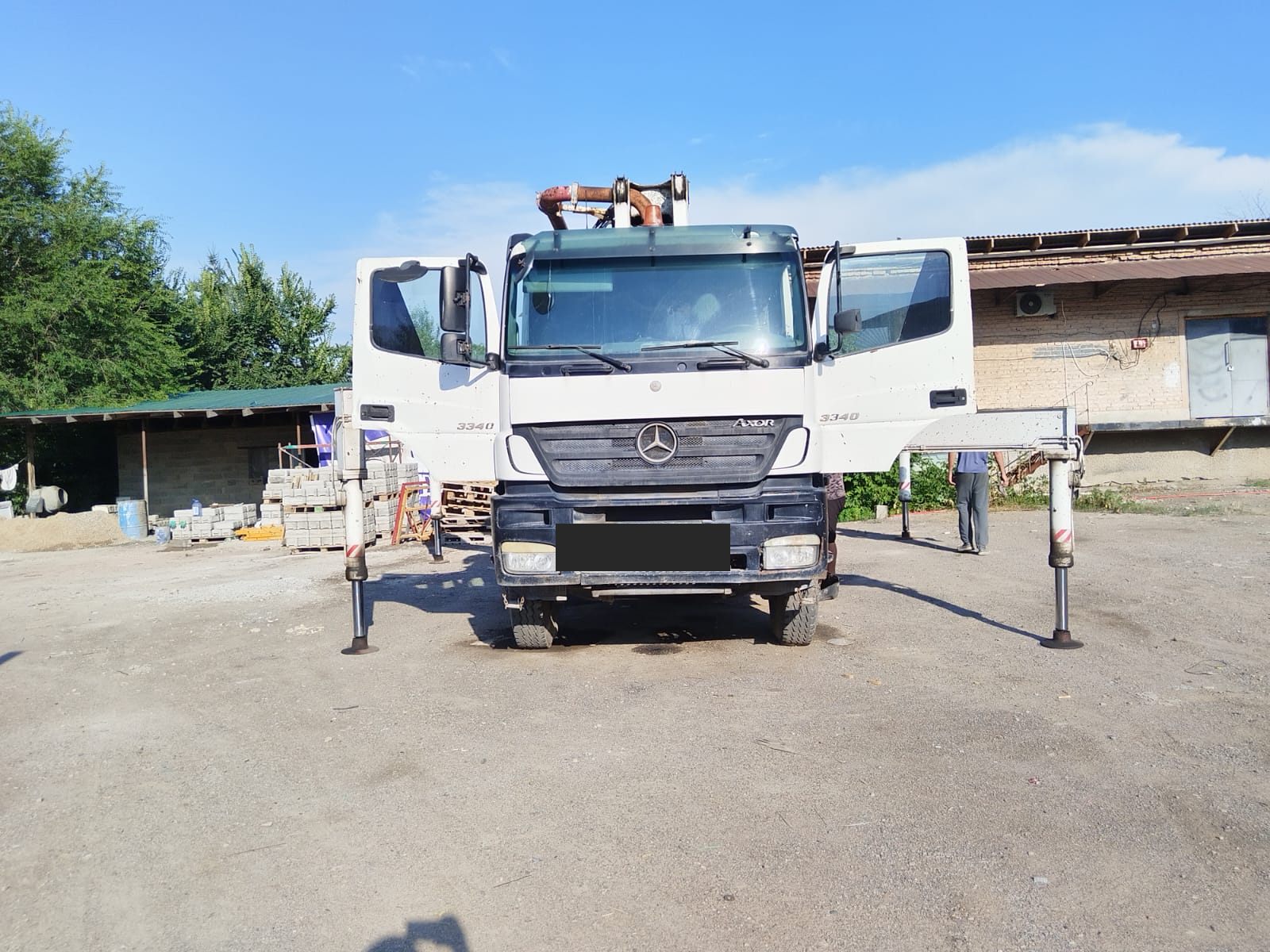 Бетононасос Mercedes-Benz Axor 3340 спереди на выдвинутых опорах — залоговая спецтехника на торгах в Алматы